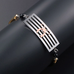 Fashionable tri-color titanium bracelet with rose gold bow and black beads on matte stand