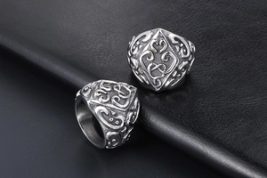 Macro shot of vintage relief patterns on retro stainless steel rings on black leather