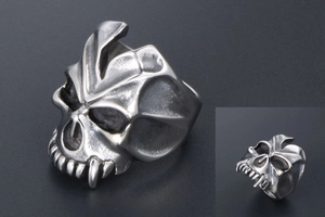 Detailed macro view showing the intricate monster skull carvings and vintage silver finish