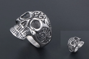Macro view of vintage silver steel skull ring with embossed vine patterns and gothic details