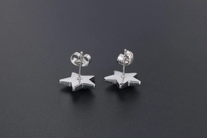 Macro detail of silver star stud earrings with butterfly backings and polished finish