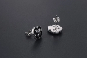 Macro shot of retro men's shield studs featuring black cross inlay and brushed metal finish