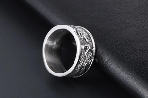 Détail du relief de dragon sur bague en acier inoxydable argenté sur cuir noir
