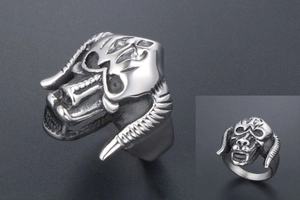 Detail of gothic monster skull ring with horns and fangs in vintage stainless steel finish
