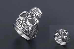 Macro detail of gothic skull ring in matte titanium steel with intricate floral carvings