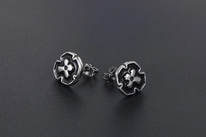 Macro shot of silver and black enamel cross earrings with polished stainless steel finish