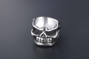 Detailed side view of punk skull ring with polished stainless steel texture