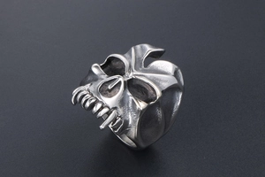 Macro shot of gothic punk skull ring showing detailed textured teeth and hollow eyes