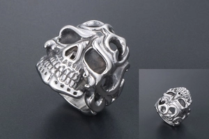 Macro shot of silver gothic skull ring featuring hollow filigree and punk metal texture