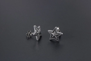 Macro shot of retro star stud earrings with radial texture and butterfly backs