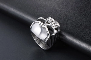 Macro detail of gothic skull ring with vintage finish on black leather texture