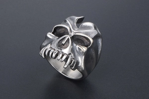 Detail of vintage gothic monster skull ring with polished finish and dark bone crevices