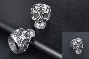 Close-up of vintage gothic skull ring with fleur-de-lis relief and oxidized finish