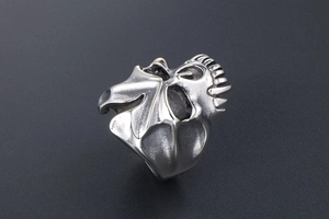Macro detail of retro gothic skull ring with oxidised silver finish and bat wings design