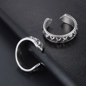 Vintage silver punk rivet open rings set with spikes on black leather background