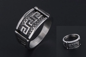 Close-up of vintage titanium steel ring featuring Greek meander pattern and textured mesh detail