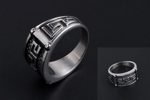 Macro detail of men's steel ring with vintage Greek key pattern and textured finish