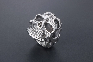 Detailed view of vintage silver skull ring with gothic fire hollowed-out band carving