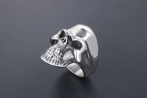 Detailed close-up of a silver skull ring with vintage finish and intricate bone textures