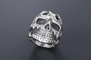 Detailed view of vintage gothic skull ring with flame patterns and silver finish