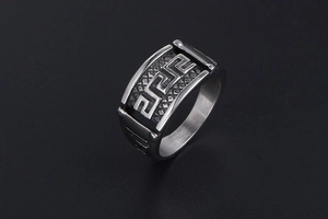 Macro shot of men's wide titanium steel ring with embossed Greek key pattern and black inlay