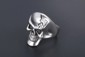 Gros plan sur une bague tête de mort punk vintage avec texture craquelée et oxydation noire