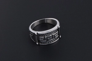 Macro detail of retro steel ring featuring Greek meander relief and textured grid finish