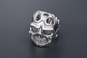 Macro detail of vintage gothic skull ring featuring intricate flame texture and steel finish