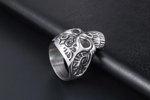 Detailed relief carving of vintage fleur-de-lis skull ring in polished titanium steel