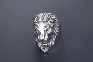 Detailed close-up of a silver lion head ring with punk style metal carving details