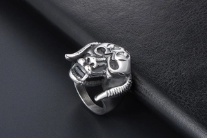 Macro shot showing the intricate texture of the silver bull head carving on a punk ring