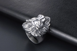Macro detail of the silver lion head ring showing embossed texture on black leather