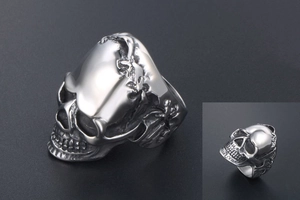 Close-up of gothic skull ring with intricate wing details in polished silver steel