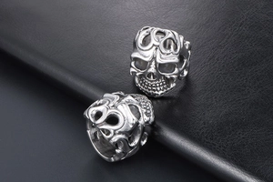 Detail view of two silver vintage skull rings with gothic punk openwork patterns