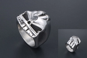 Macro detail of gothic skull ring with double swords relief in polished steel finish