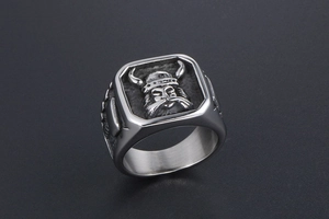Détail macro d'une bague de guerrier viking en acier titane avec face carrée gravée