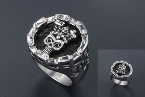 Close-up of vintage steel skull ring with crown detail and chain border for men