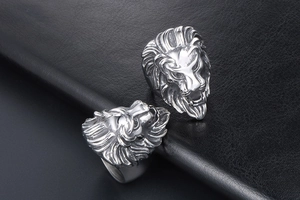 Detailed macro view of the intricate lion head carving on a polished steel ring