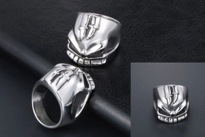Macro detail of men's punk skull ring featuring embossed daggers on polished steel