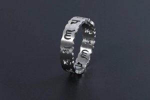 Détail d'une bague en titane brossé avec mantra ajouré et bords ondulés au fini argenté