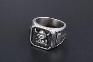 Gros plan de la bague Viking carrée avec masque de pirate en relief et marteau de Thor