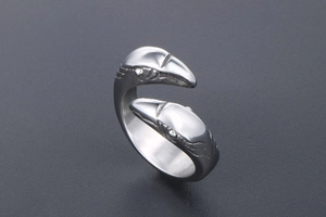 Close-up of dual eagle head engravings on a stainless steel open ring with vintage texture