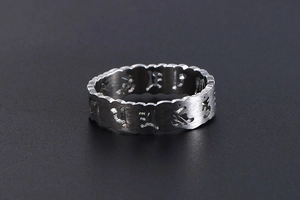 Vue macro de la bague en acier inoxydable avec caractères évidés et finition brossée