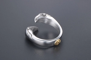 Detailed view of vintage eagle head carvings and golden medal on stainless steel ring