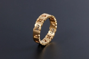 Macro d'une bague mantra dorée avec bords ondulés et finition brossée mate élégante