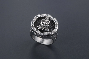 Macro view of silver punk skull ring with mechanical gear edges and engraved tribal patterns