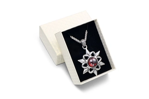 Star pendant necklace with red gemstone in a premium white quilted gift box