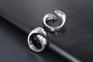 Detailed view of dual eagle head rings in silver finish with golden cross emblem