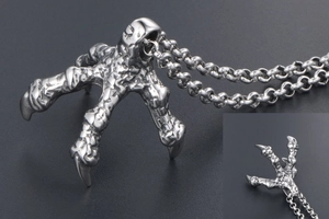 Macro detail of gothic punk dragon claw pendant with silver vintage textured finish