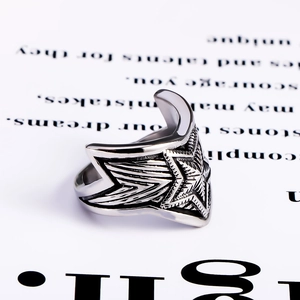 Macro detail of retro star ring with wing carvings on polished stainless steel band